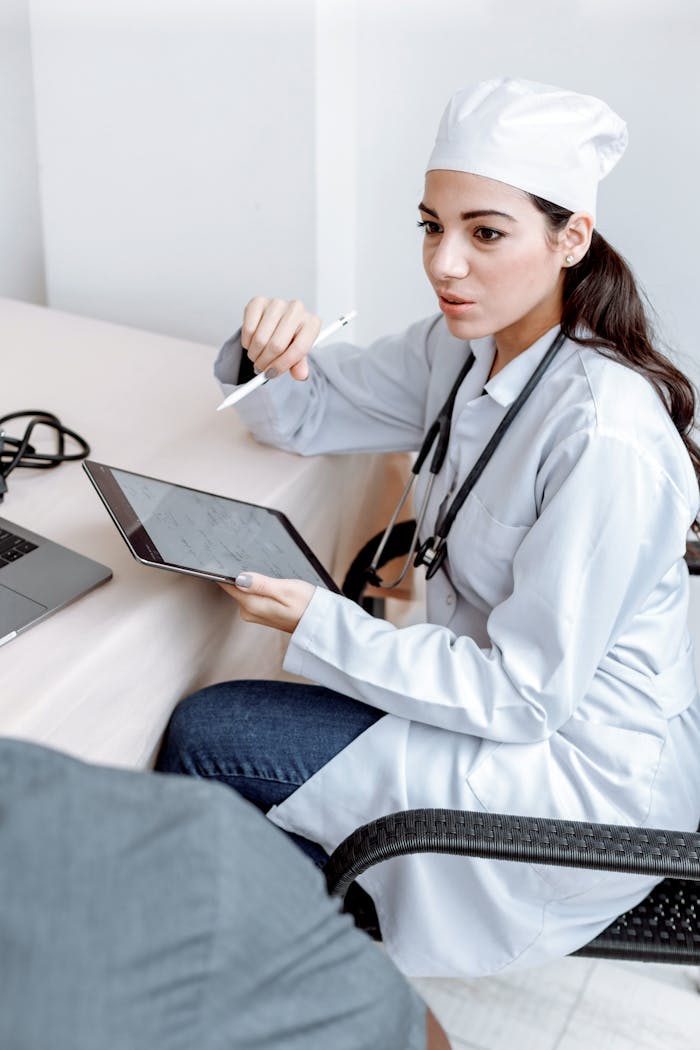 Female doctor discussing results with patient using a tablet in a clinical setting.